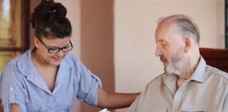 LGA RESPONDS TO AGE UK REPORT ON CORONAVIRUS CARE COSTS carer reading to an older man