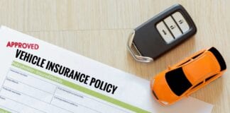 CEO EXPERT COMMENT: Car insurance renewal costs rise over the last quarter top view of approved vehicle insurance policy with car key and car toy on wooden desk