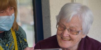 LGA responds to Public Accounts Committee report on the adult social care market Carer in mask shares an image on her phone with elderly lady WEB