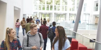 COVID delayed your decision about university? Plan now for Clearing! Students holding tablets and phone talk in university lobby 597958816 1258x838