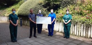 Retired headteacher Dic Evans, who ran 1,000 miles in 100 days, has raised a massive £14,374 for the chemotherapy unit at Bronglais Hospital. Dic Evans cheque picture scaled