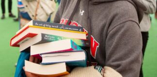 Your Summer Companion Must Be One of These Books compass girl with stack of books