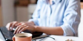 Survey highlighted that Brits are considering taking a career break in 2022 7 Remote working from home Freelancer workplace in kitchen with laptop cup of coffee