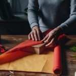 woman wrapping book as christmas gift