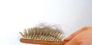 Hair Loss In Women: Causes and Cures woman holding wooden hair brush full has fallen out detail horizontal view female hand hairbrush loss issue 146122931