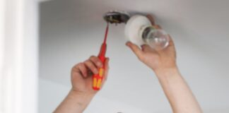 NICEIC ADVICE FOR LIGHTING UP YOUR HOME THIS WINTER electrician workin on light fitting cr NICEIC min scaled