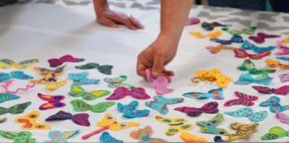 Wales’ children’s hospices bid to land #ReachEveryChild butterfly funding message at Senedd Individual unique coloured butterflies made by children with life shortening conditions being hand applied to the ReachEveryChild butterfly emblem 1 scaled e1718205519820