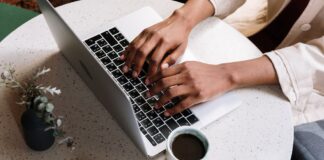 Sector cyhoeddus Cymru yn arwain y ffordd o ran defnyddio AI mewn modd cyfrifol Person using laptop