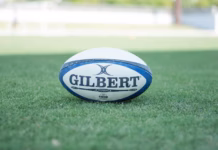 Wales squad named for Wheelchair Rugby League World Cup A photo of a Rugby ball with the text "GILBERT" on it underlined. It is in the middle of a rugby pitch.